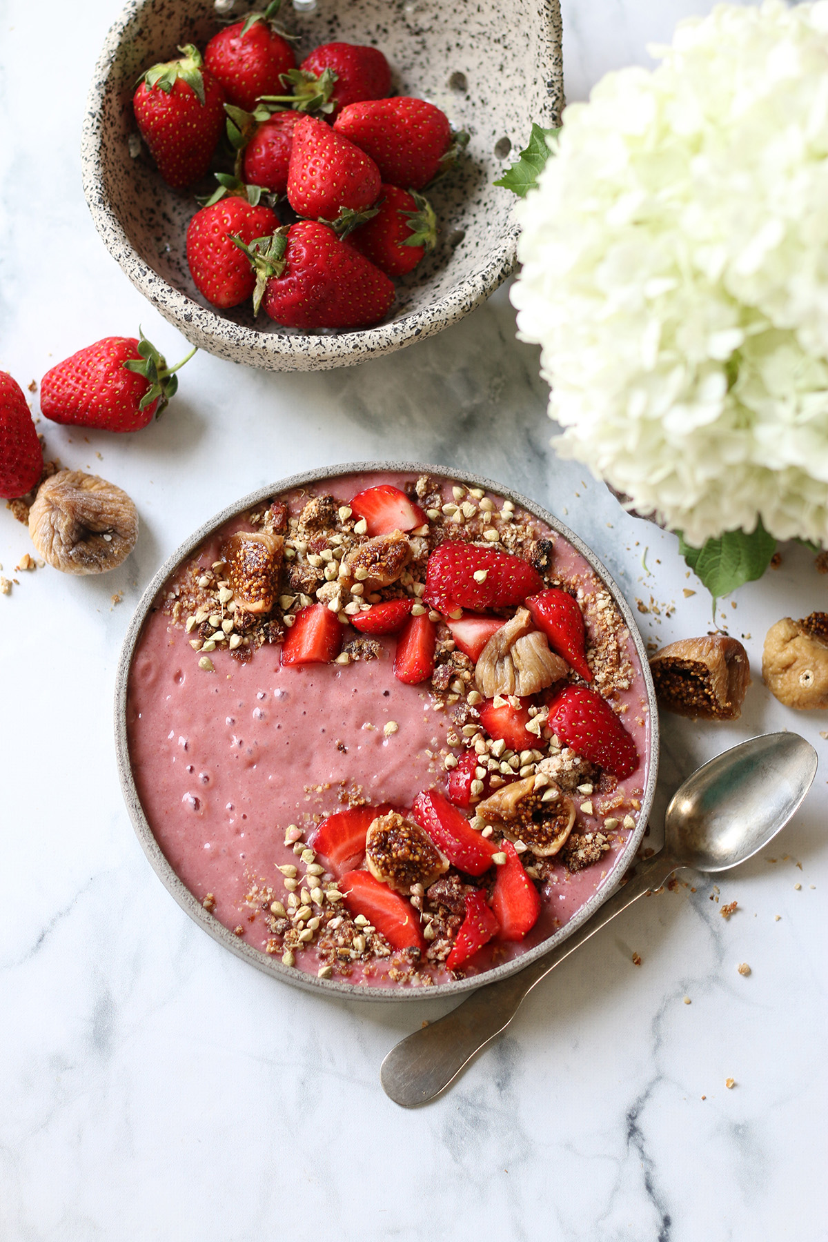 Delicious vegan smoothie bowl with fresh strawberries, figs, and granola